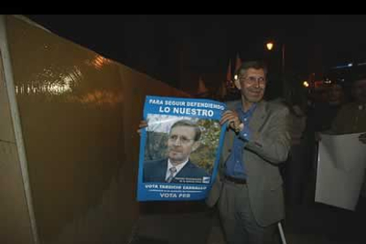 Tarsicio Carballo muestra el cartel con su imagen antes de pegarlo.