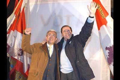 Los candidatos del PP a la Presidencia de la Junta, Juan Vicente Herrera (derecha) y a la Alcaldía de Burgos, Juan Carlos Aparicio, saludan desde una plataforma al inicio de la campaña.