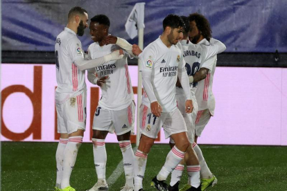 Los jugadores del Real Madrid felicitan a Karim Benzema tras marcar ante el Getafe. JUANJO MARTÍN