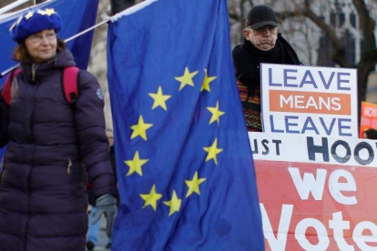 Una activista anti-brexit exhibe una bandera europea junto a un partidario de abandonar la UE en Londres.