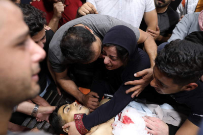 La familia de un palestino muerto en un ataque israelí a Hebrón llora su cadáver. ABED AL HASHLAMOUN