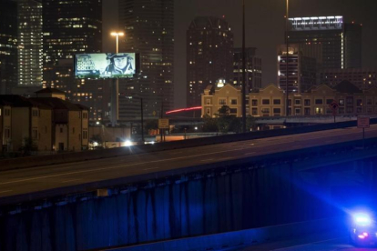 Un coche de policía patrulla las calles de Houston después del anuncio del toque de queda anunciado por el alcalde de la ciudad, Sylvester Turner
