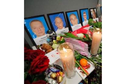 Velas ante retratos de los fallecidos en Kiev.