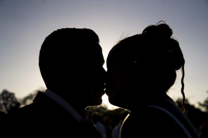 Una pareja sella con un beso su compromiso matrimonial en una puesta de sol muy romántica. JORGE TORRES