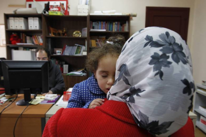 Una mujer de origen marroquí con su hija en un centro de información en León