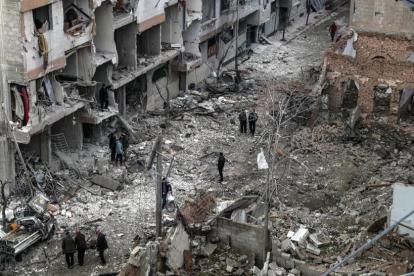 Vecinos inspeccionan los edificios en ruinas tras varios bombardeos el día anterior en Duma, feudo rebelde de Guta Oriental (Siria), el 22 de febrero.