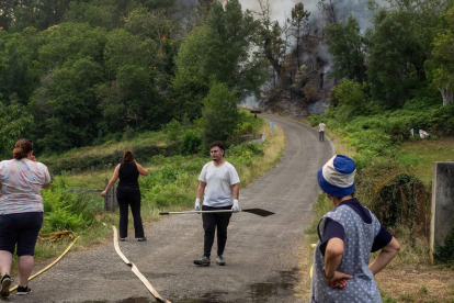 Los vecinos combaten el fuego en la aldea de Froxan, O Courel, en Lugo. EFE/ELISEO TRIGO