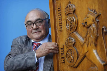 Joaquín Fidalgo posa con el escudo de la peña que preside en la cafetería JV, domicilio social de la Peña Real Madrid-Cultural Leonesa que esta temporada cumplirá 63 años de existencia, de ellos 33 bajo su mandato. JESÚS