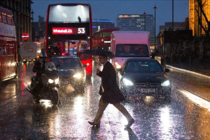 Un peatón cruza una avenida de Londres.