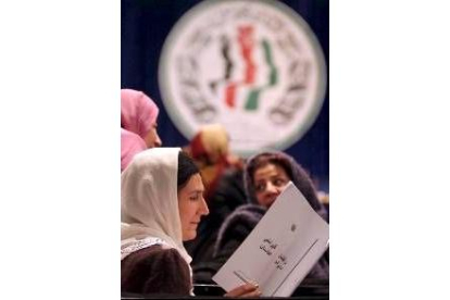 Una mujer afgana lee el texto de la Constitución aprobada ayer