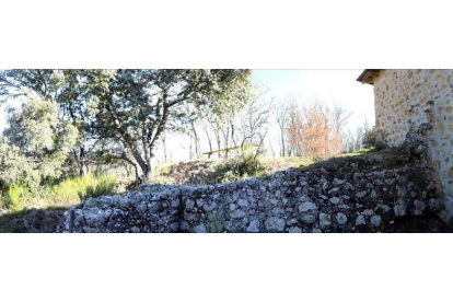 Muro de mampostería contiguo a la ermita de Santa Ana, que podría pertenecer a la capilla del castillo. Derecha, restos del perímetro que rodeaba el castillo. RICARDO GARCÍA