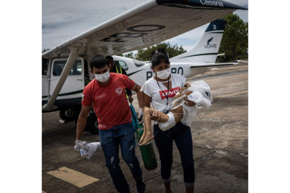 Una madre yanomami carga a su hijo enfermo tras aterrizar en Boa Vista. RAPHAEL ALVES