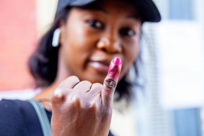 Una senegalesa muestra su dedo manchado con tinta endeleble, tras depositar su voto en las elecciones presidenciales del 24 de febrero del 2019.