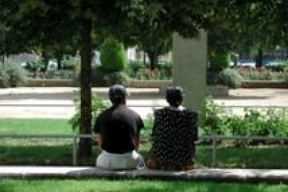Una pareja descansa en un jardín de León