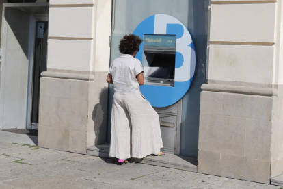 Una clienta saca dinero de un cajero automático de una entidad. RAMIRO