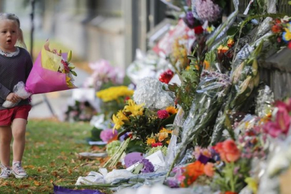 Una niña pone flores en el memorial de recuerdo del atentado en Christchurch, el pasado mes de marzo.
