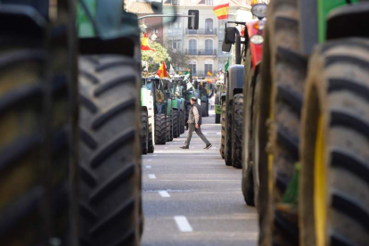 Un hombre pasa entre los tractores que se han manifestado por las calles de Valladolid.