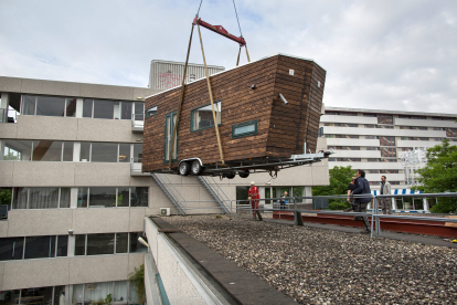 Subiendo una vivienda estilo ‘mobile home’ compacta a la azotea durante un ensayo. DARKOPEN