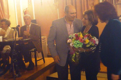 La viuda de Ángel Barja recibe un ramo durante el homenaje.
