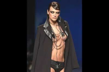 La modelo, que lleva lentilla blancas, lo que para David Delfín producen efecto de muerte, desfila con un ligero conjunto de abrigo y minishorts negros con cables y bombillas a modo de collares