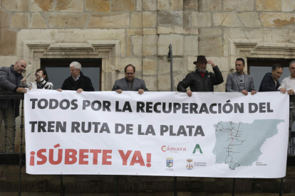Autoridades de Astorga y La Bañeza, organizaciones empresariales y asociaciones ferroviarias, en el despliegue de la pancarta. FERNANDO OTERO