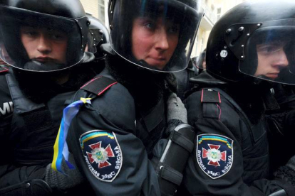 Miembros de la policía se protegen del enfrentamiento contra los manifestantes. AFP / Kiev, Ucrania