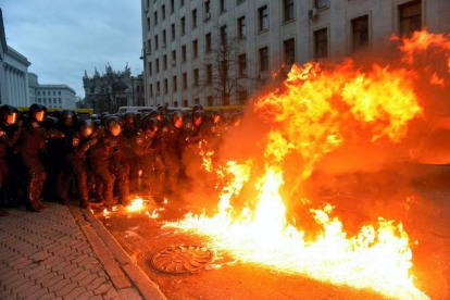 Un cóctel molotov explota frente al muro policial que evita la entrada de los manifestantes en el edificio de administración de la presidencia. AFP / Kiev, Ucrania