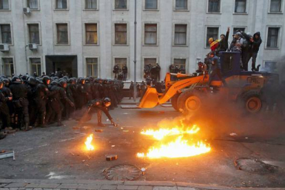 Unos manifestantes montan en una excavadora con la intención de romper con el muro policial. EFE / Kiev, Ucrania