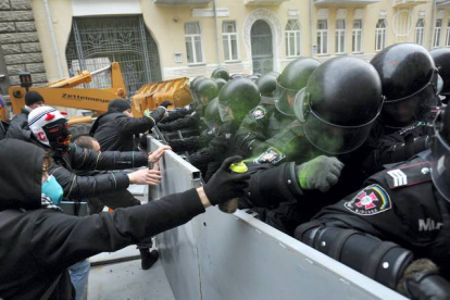 Un manifestante hecha pintura verde con un espray a la policía al lado del edificio de administración presidencial. EFE / Kiev, Ucrania