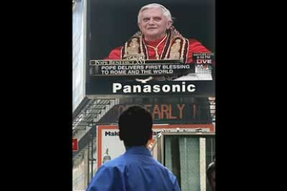 Un hombre observa a Ratzinger en una pantalla, en Times Square, en Nueva York.