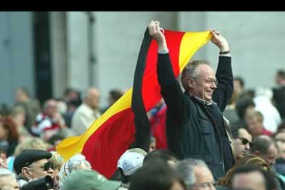 Un hombre ondea una bandera alemana poco antes de la fumata blanca.