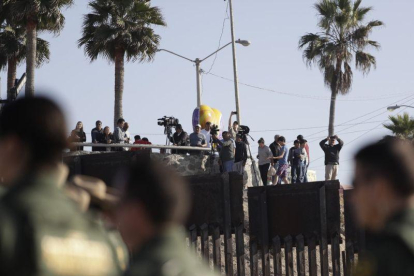 Migrantes en Tijuana, México, miran desde el otro lado del muro durante una visita de la Secretaria de Seguridad, Kirjsten Nielsen.