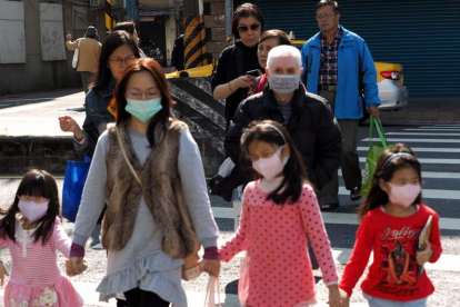 La población china se protege con mascarillas para evitar el contagio.