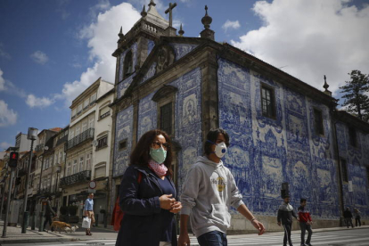 Dos personas caminan frente a una iglesia en Oporto. JOSE COELHO