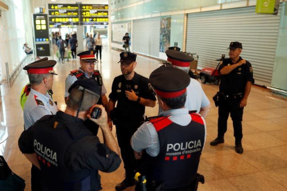 Mandos policiales de los Mossos y del Cuerpo Nacional de Policía en el aeropuerto del Prat. ALEJANDRO GARCÍA