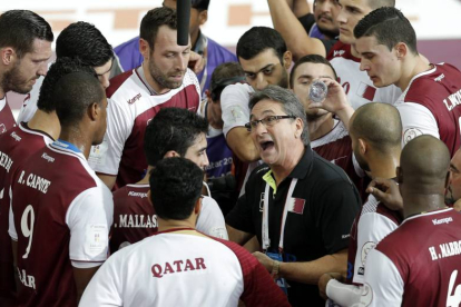El entrenador de Qatar, el español Valero Rivera (c), habla con los jugadores de su equipo durante el partido de semifinales del Mundial de balonmano disputado entre Polonia y Qatar en el Lusail Multipurpose Hall, a las afueras de Doha, en Qatar, hoy, vie
