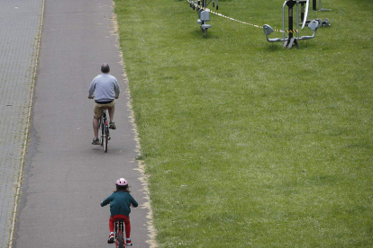 Dos leoneses en bici por el paseo del río. ARCHIVO