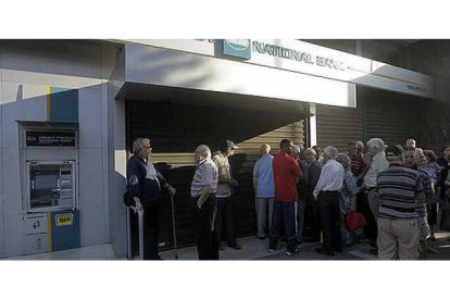 Numerosos ciudadanos griegos esperaban la mañana del 29 de junio de 2015 frente a las sucursales de los bancos griegos para extraer su dinero. ORESTIS PANAGIOTOU / EFE