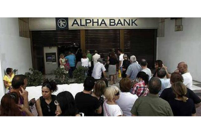 Decenas de personas hacen cola para sacar dinero de un banco en Atenas. ALEXANDROS VLACHOS / EFE