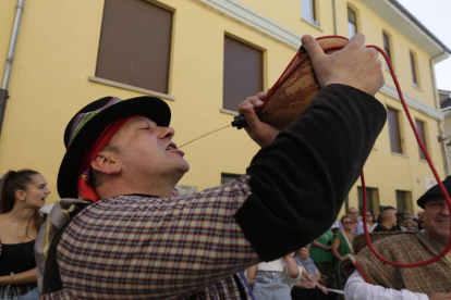 Un hombre bebe de una bota de vino durante l desfile de carros de San Froilán. FERNANDO OTERO PERANDONES