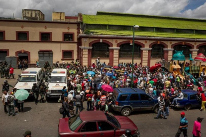 Un grupo de personas hace fila para poder comprar alimentos el martes en Caracas.