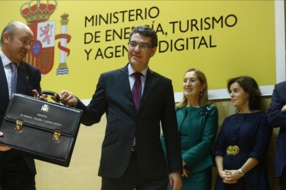 El ministro de Energía, Turismo y Agenda Digital, Álvaro Nadal, recibe la cartera ministerial de manos del titular de Economía, Luis de Guindos.