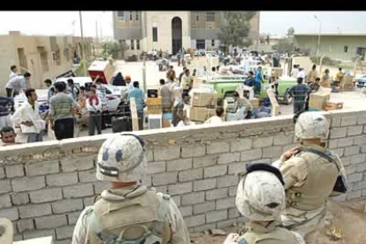 Marines observan a iraquíes saqueando un edificio gubernamental en un suburbio de la capital iraquí.