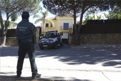 Un agente de la Guardia Civil custodia el exterior del domicilio donde se han encontrado los cadáveres.