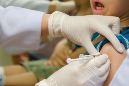 Una enfermera inyectando a un niño una vacuna, en una foto de archivo.