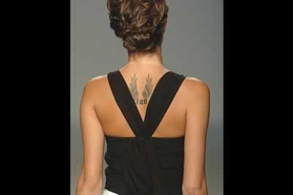 Detalle de la espalda de una blusa negra con recogido cruzado.