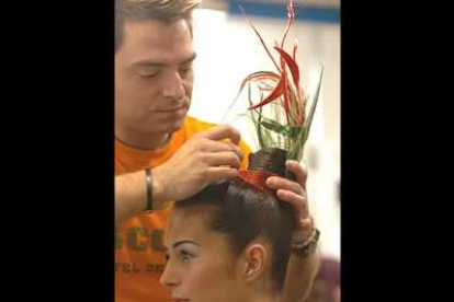 Un peluquero realiza los últimos retoques al peinado de una de las modelos antes del inicio del desfile de Montesinos.