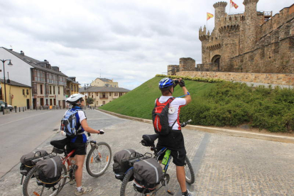 Dos cicloturistas fotografían el castillo de Ponferrada.