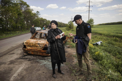 Olga Kotenko, de 67 años, acompaña a la policía e investigadores de crímenes de guerra mientras visitan el área por un posible crimen contra Volodymyr Kotenko, de 38 años, a manos del ejército ruso en el área de Járkov.  ESTEBAN BIBA