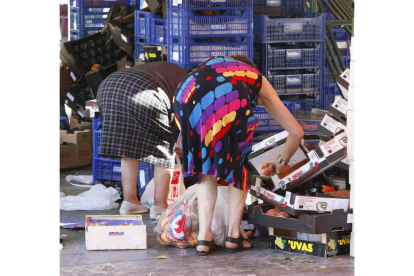 Unas mujeres buscan alimentos entre los desperdicios del mercado. JESÚS F. SALVADORES